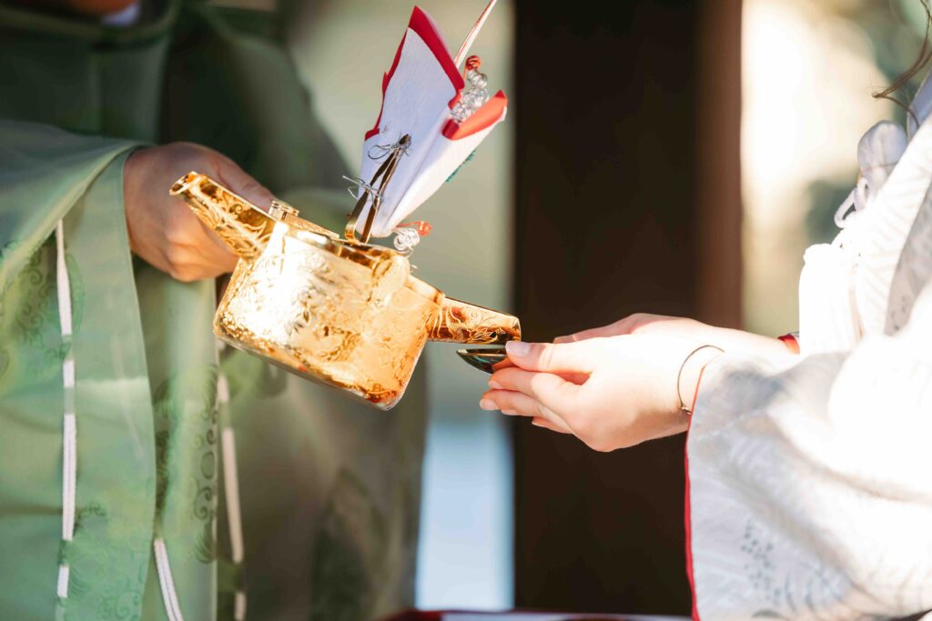 Bride and groom participating in a traditional Shinto ritual at a Kyoto shrine wedding
