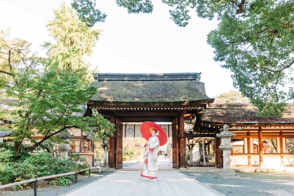 Elegant portrait of the bride in the serene grounds of a Kyoto shrine during their intimate autumn wedding