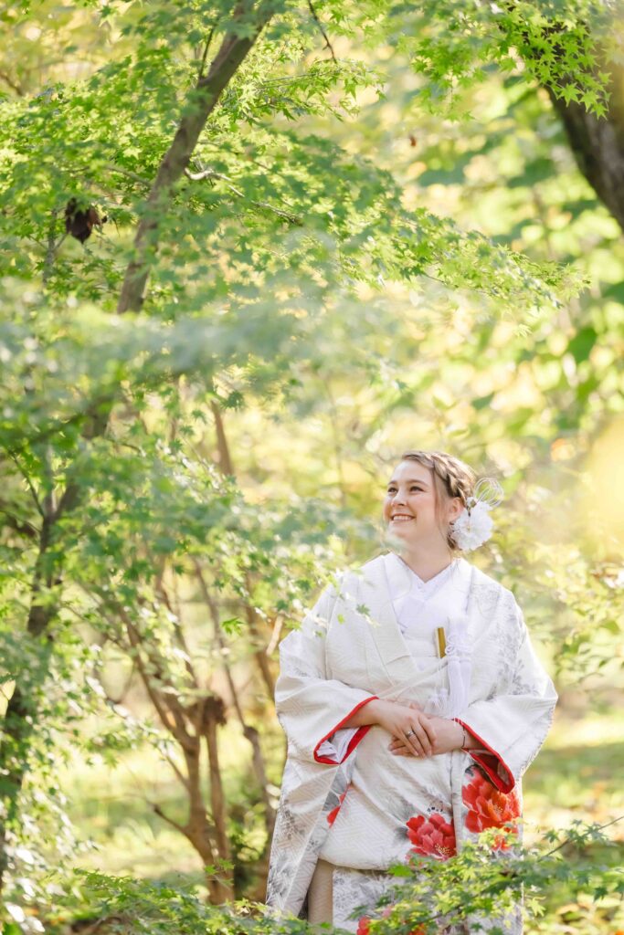 Beautiful portrait of the bride smiling among greenery during her elegant autumn wedding in Kyoto
